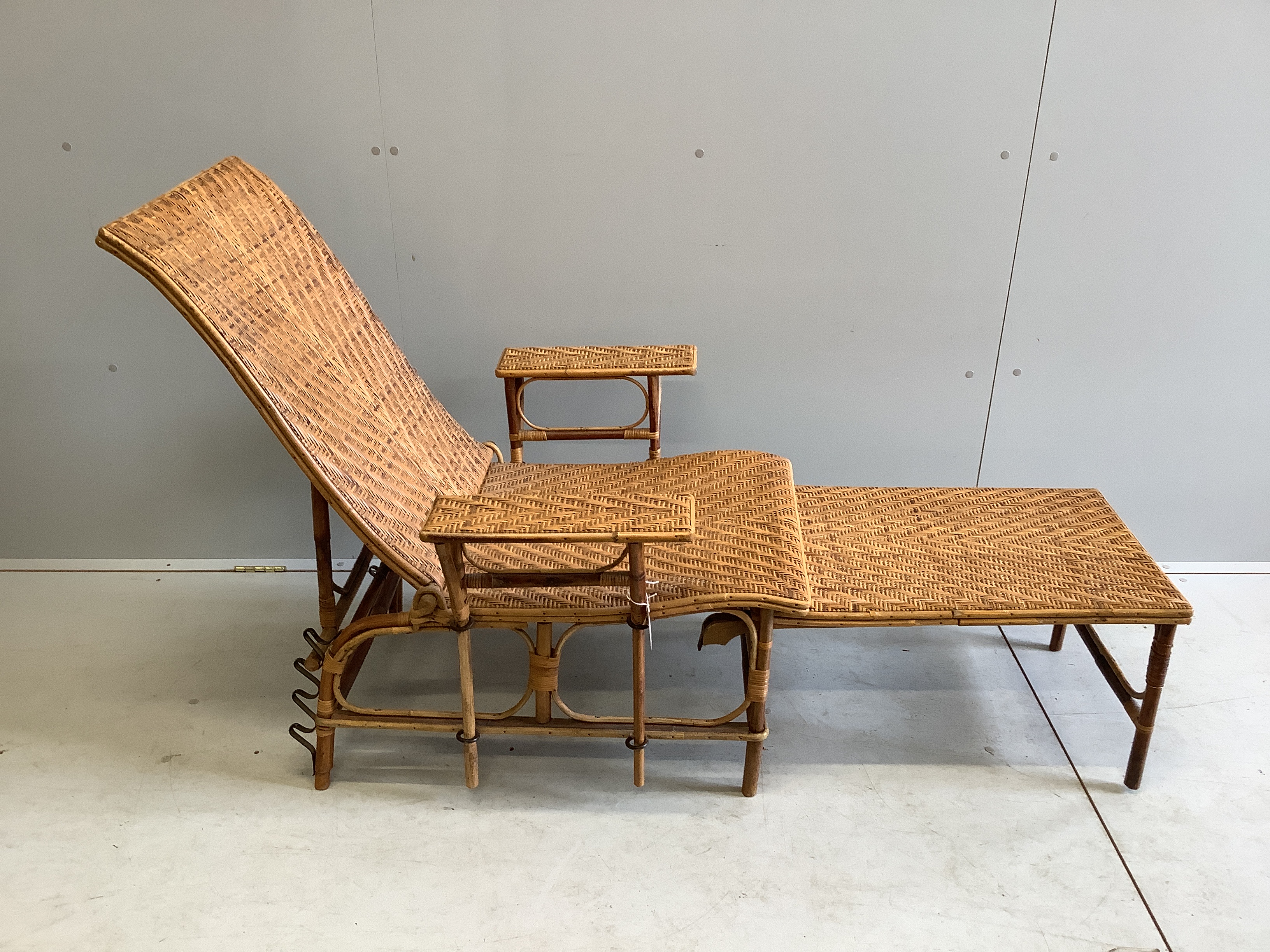 An early 20th century French caned bamboo reclining garden chair, with integral footrest, width 75cm, height 92cm
